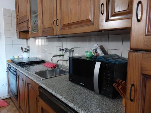 a kitchen with a sink and a black microwave at Appartamento al mare di Liguria e Toscana in Marina di Massa