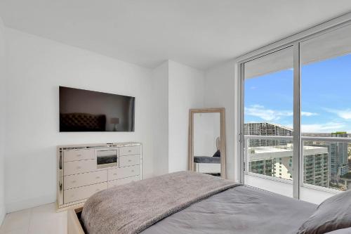 Dormitorio blanco con cama y ventana grande en PENTHOUSE 2BR ICON WHOTEL Brickell Miami en Miami