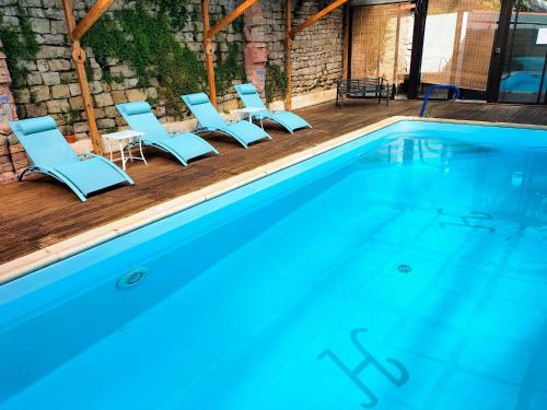un grupo de sillas y una piscina en Hotel Restaurant Herard, en Bourbonne-les-Bains