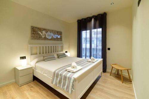 a bedroom with a large bed and a window at APARTAMENTO VELA in Blanes