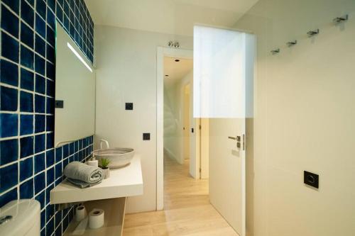 a bathroom with a sink and a blue tiled wall at APARTAMENTO VELA in Blanes