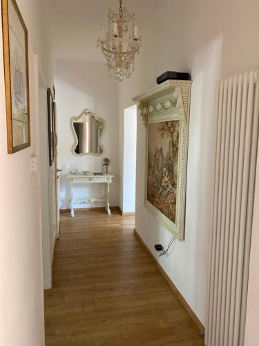 un pasillo con una pintura en la pared y una lámpara de araña en Film festival bedroom, en Lido de Venecia