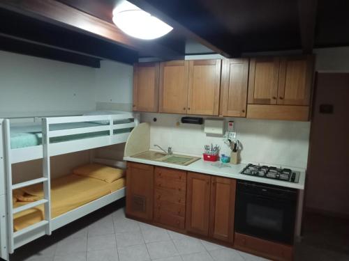 a small kitchen with a bunk bed and a stove at Casa Sole e Mare indipendente a Triscina in Triscina