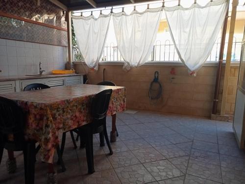 a kitchen with a table and chairs and windows at Casa Sole e Mare indipendente a Triscina in Triscina