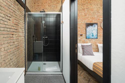 a bathroom with a shower and a bed in a room at Smartflats - the Brooklyn Antwerp in Antwerp