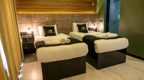 two beds in a hotel room with white sheets at Crown Salamis Hotel in Mağusa