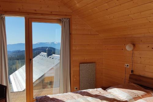 a bedroom with a bed and a large window at Chalet Luna in Klippitztorl