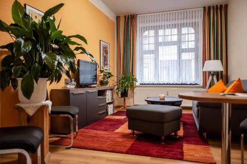 een woonkamer met een televisie en een tafel en stoelen bij Pension Wehner in Torgau