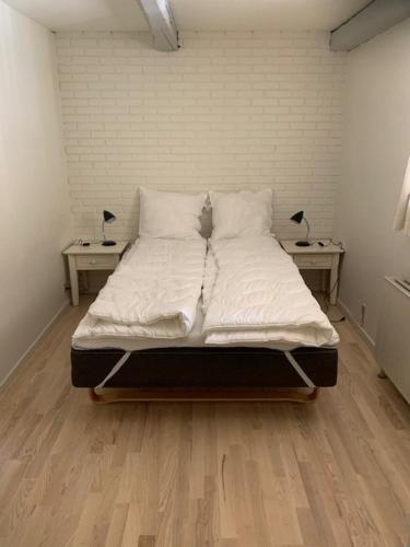 een groot bed in een kamer met 2 nachtkastjes bij Dyrlundgård in Helsinge