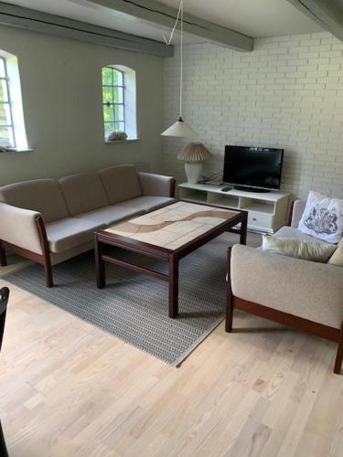 a living room with a couch and a coffee table at Dyrlundgård in Helsinge