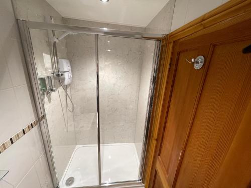 a shower with a glass door in a bathroom at Quaysiders Lakes Resort - Quaysiders Club in Ambleside