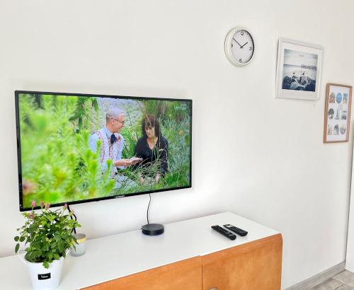 TV de pantalla plana en una pared blanca en la sala de estar. en Luff Gdynia Morska, en Gdynia