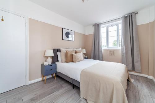 ein Schlafzimmer mit einem weißen Bett und einem Fenster in der Unterkunft The Crystal Palace Collection in London