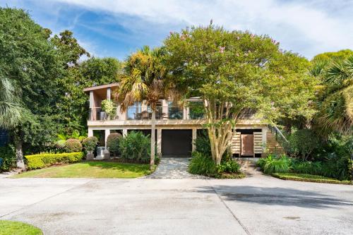 a house with a palm tree in front of a driveway at Folly Vacation 620 Entire Home plus Apt, one block to the beach and pet friendly in Folly Beach