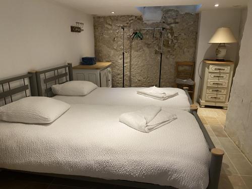 a bedroom with two beds and a dresser at Gite des vieilles pierres in Seigy