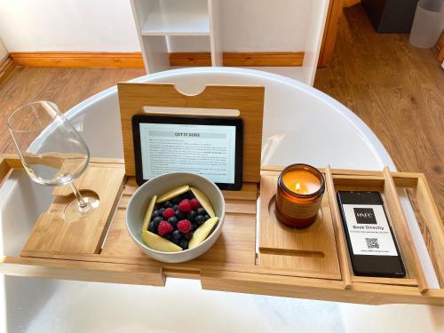 uma mesa de madeira com uma taça de fruta e uma bebida em Mini-studio by HNFC Stays em South Shields
