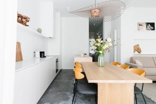 a kitchen and dining room with a wooden table and chairs at High-end flats at South area in Antwerp