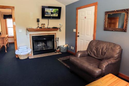 a living room with a leather chair and a fireplace at Timber Creek Chalets- 8 chalet in Estes Park