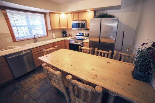 a kitchen with a wooden table and a refrigerator at Timber Creek Chalets- 8 chalet in Estes Park
