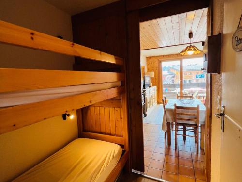 a bedroom with a bunk bed and a dining room with a table at Studio Cabine ensoleillé aux Saisies – 4 pers, Balcon Sud, Proche Pistes et Commerces - FR-1-293-166 in Les Saisies