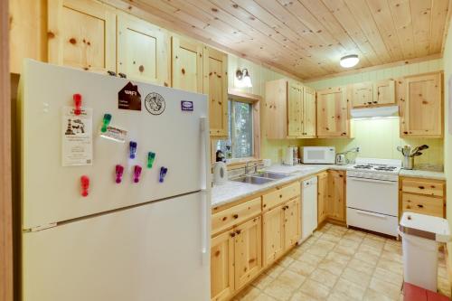 een keuken met een witte koelkast en houten kasten bij Waterfront Fayette Vacation Rental on Parker Pond! in Fayette