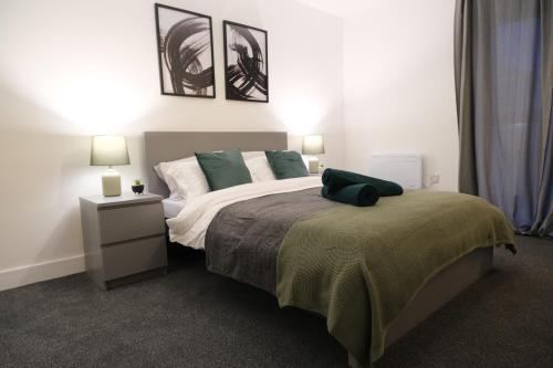 a bedroom with a bed with a green pillow on it at Richmond Village Apartments in Cardiff