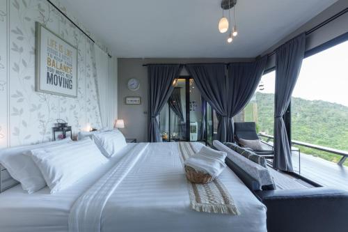 a bedroom with a large white bed and a couch at The Proud Resort @Khao kho in Khao Kho
