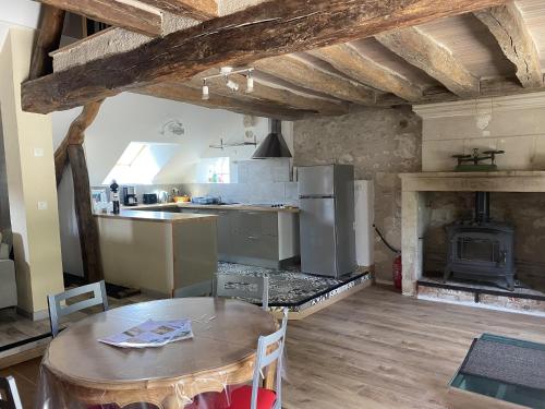 a kitchen and dining room with a table and a fireplace at Gite des vieilles pierres in Seigy