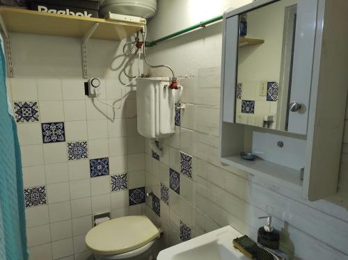 y baño con aseo, lavabo y espejo. en hoStel 3B Hab Central Baño Privado externo y Aire ac, en Salto