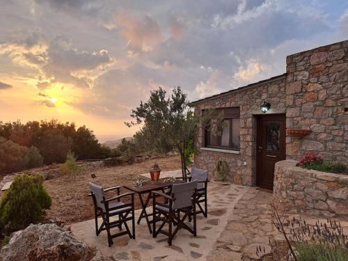 une terrasse avec une table et des chaises devant un bâtiment dans l'établissement Ηλιοβασίλεμα, à Chios