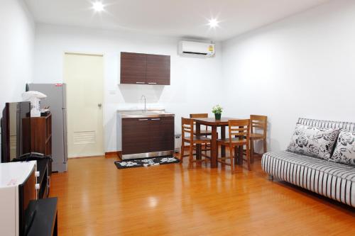 a kitchen and a living room with a table and a couch at Double DD House at MRT Sutthisarn in Bangkok