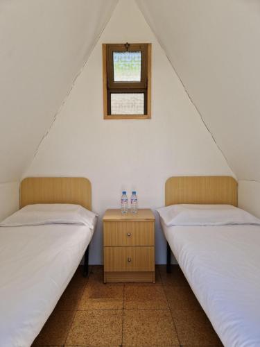 two twin beds in a room with a window at Valbom by Campigir in Sesimbra