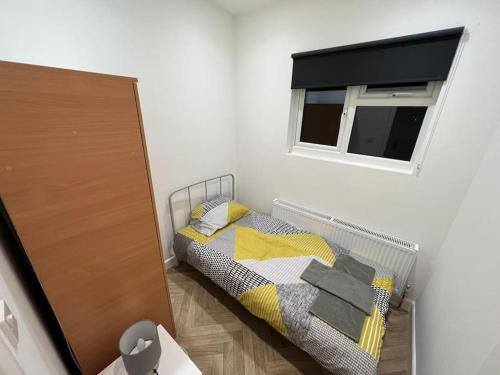 ein kleines Schlafzimmer mit einem Bett und einem Fenster in der Unterkunft Ground Flr 3-bed flat near Norbury Station in Norbury