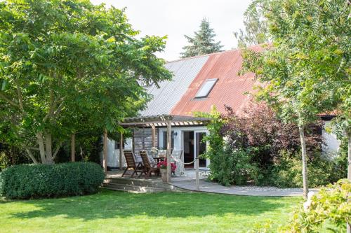 a house with a table and chairs in a yard at Villa Verde Österlen in Glemminge