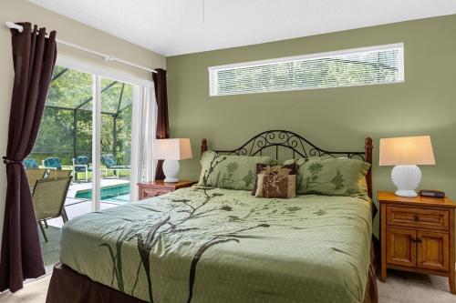 1 dormitorio con 1 cama y puerta corredera de cristal en 1061 Lake Berkley 4 Bed with Pool&Spa en Kissimmee