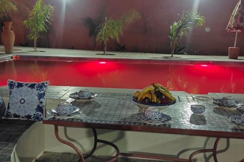 een tafel met een kom bananen erop bij Espace vert avec logement familial et piscine privée terrasse in Safi