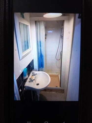 uma pequena casa de banho com um lavatório e um chuveiro em Karen's breakaway spot. em Leysdown-on-Sea