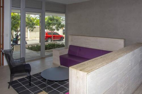 a living room with a purple couch and a chair at Brand new, with private Jacuzzi in Carlos Guerra