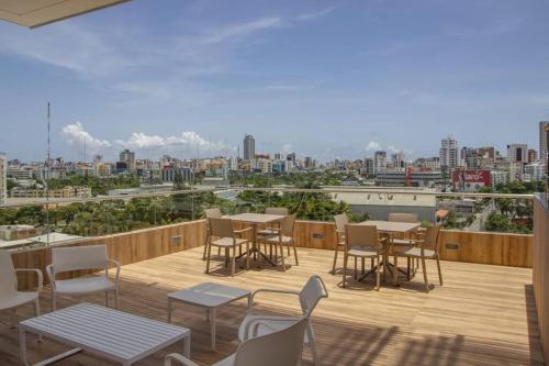 a balcony with tables and chairs and a view of a city at Brand new, with private Jacuzzi in Carlos Guerra