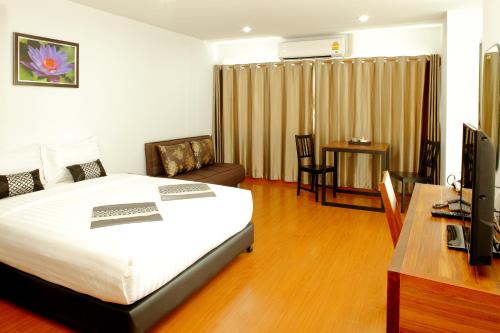 a bedroom with a bed and a desk and a television at Double DD House at MRT Sutthisarn in Bangkok