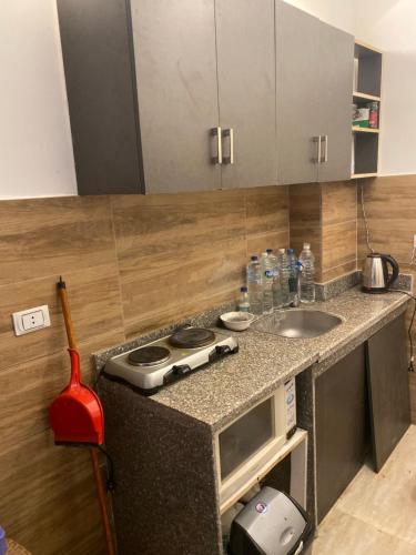 uma cozinha com um balcão com um lavatório e um fogão em قريه نيوكوست em Dawwār Muḩammad Abū Shunaynah