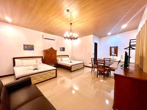 a living room with two beds and a dining room at E&R Airport Hotel in Dumaguete