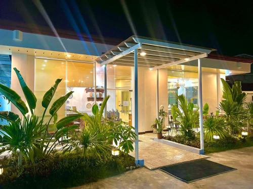a building with plants in front of it at night at E&R Airport Hotel in Dumaguete