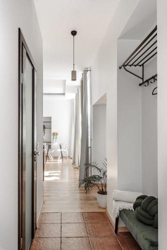 a hallway with white walls and a green couch at Spacious City Centre Apartment with Parking SELF CHECK-IN in Vilnius