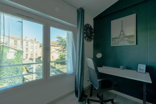 a office with a desk and a window with the eiffel tower at Le Franklin in Saint Etienne