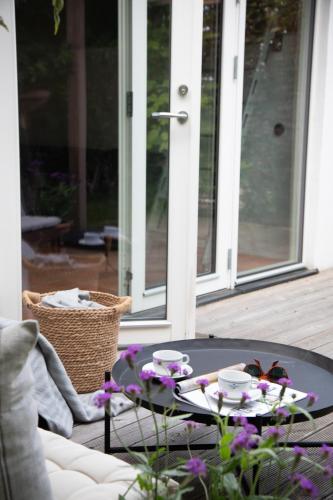 a table on a porch with cups and butterflies on it at Villa Verde Österlen in Glemminge
