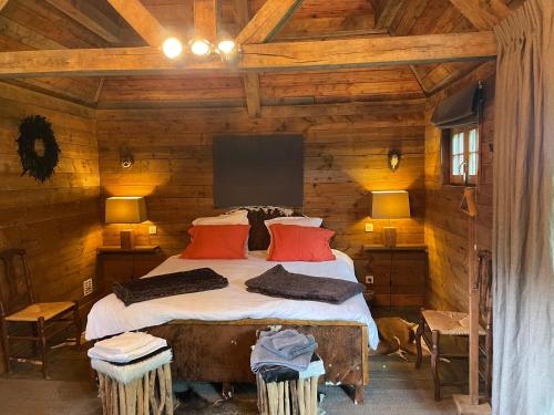 a bedroom with a bed in a log cabin at Cabane de l'R-mitage in Modave