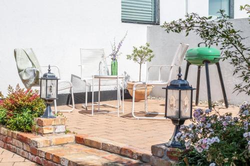 a patio with chairs and a table and lights at Villa Verde Österlen in Glemminge