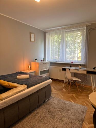 a bedroom with a bed and a desk and a table at Gdańsk Sea Apartment by YOCA in Gdańsk