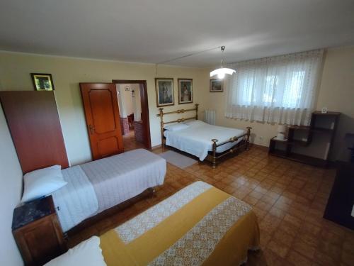 Cette chambre comprend deux lits et une télévision. dans l'établissement Villa Azzurrina, à Filettole